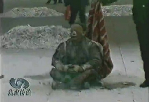 Piazza Tiananmen - Bufala dell'auto-immolazione: fotogramma delle telecamere di sorveglianza che mostra un individuo seduto a gambe incrociate, dopo che si è dato fuoco.